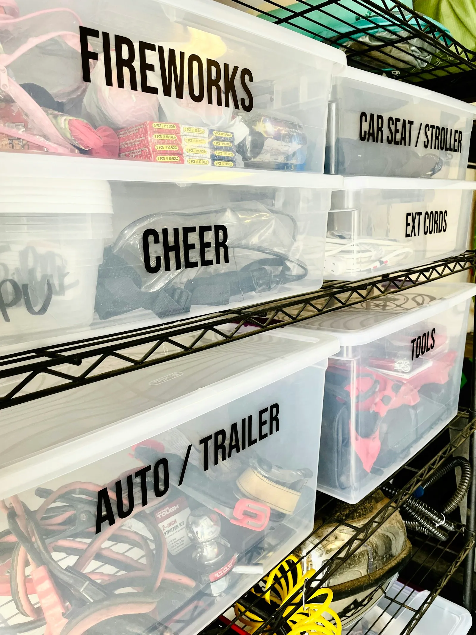 Clear plastic bins with printed labels on a wire shelving unit